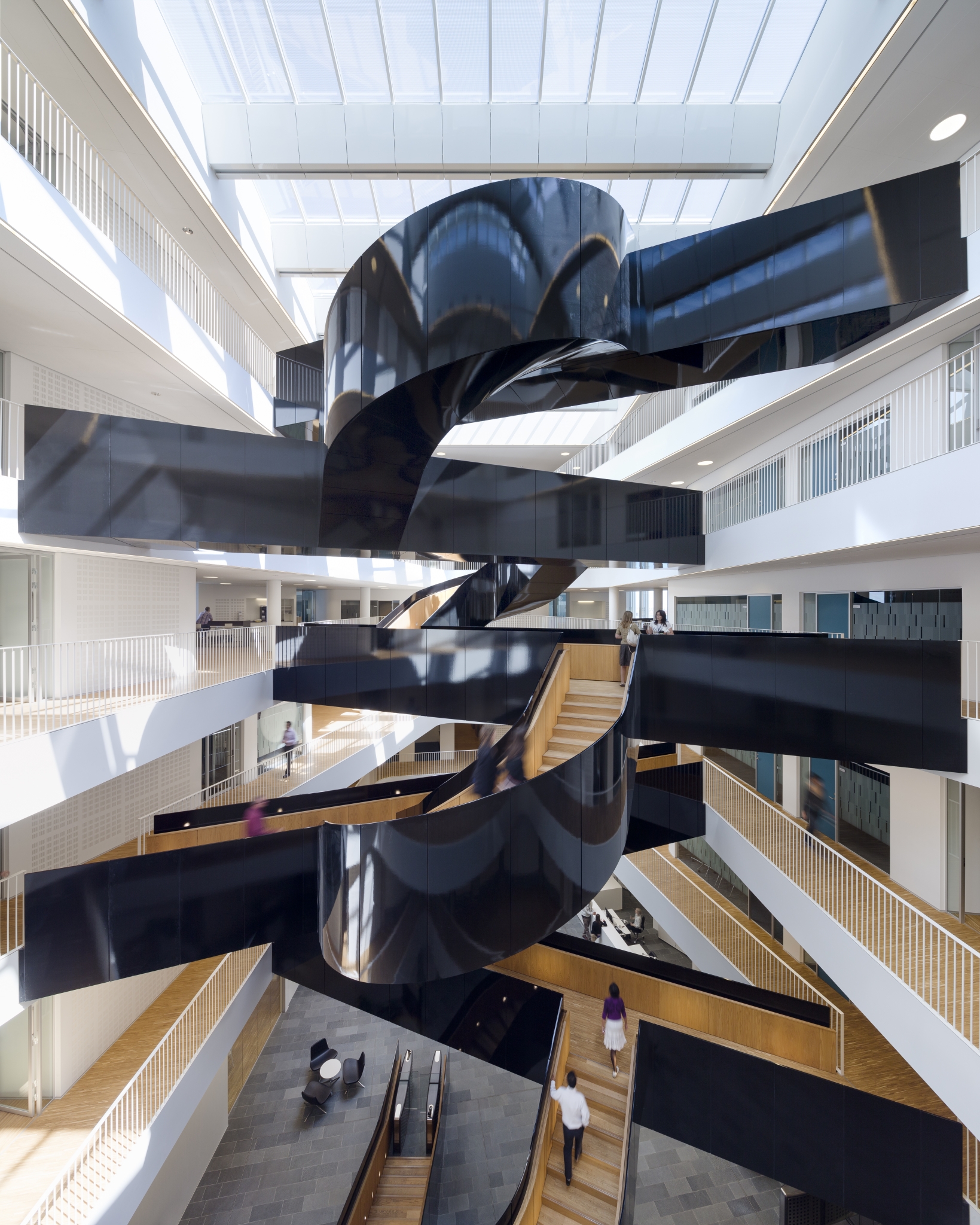 En skulpturel, sortlakeret trappe, der binder etagerne sammen