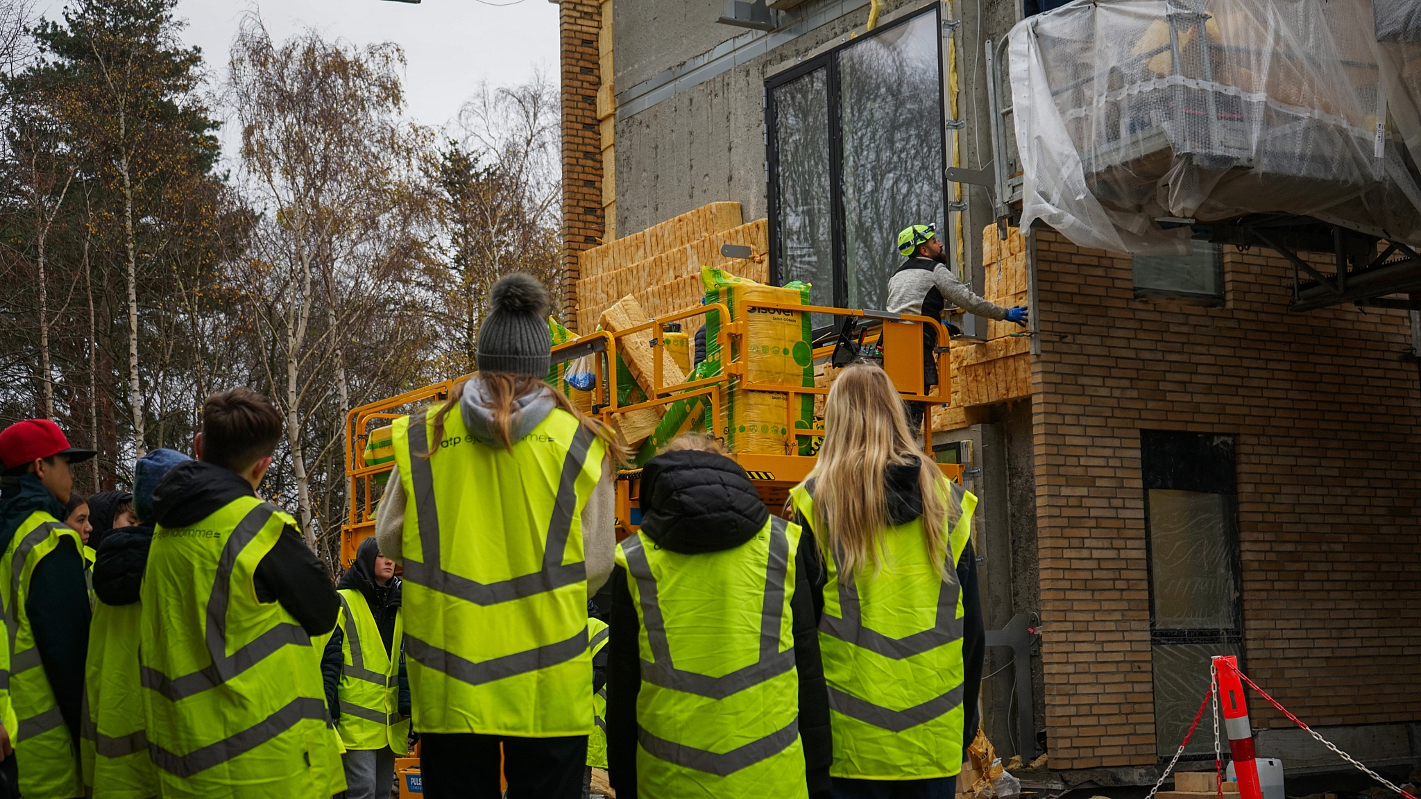 Børn og unge i gule veste på byggeplads