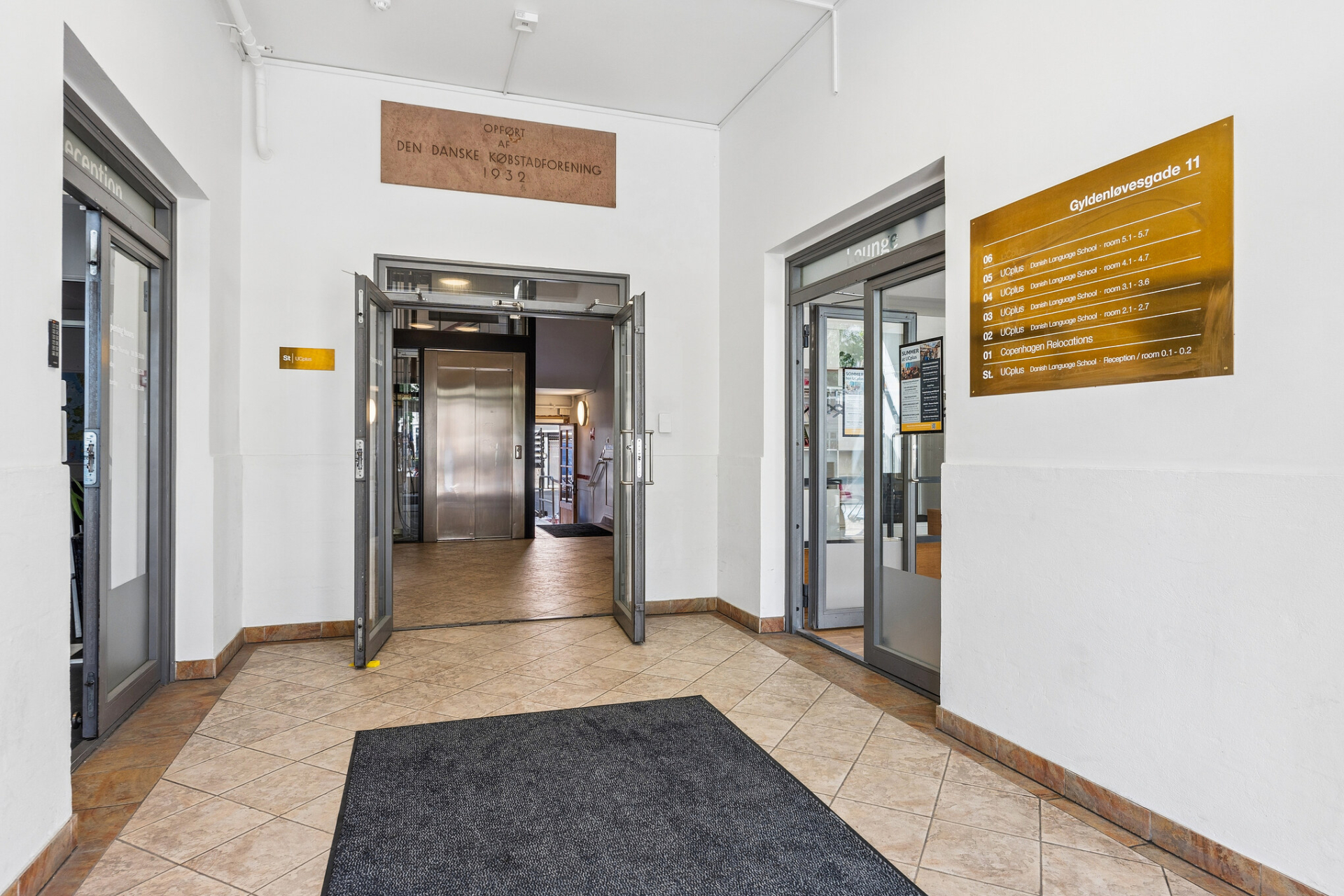 Indgangsområde med etagetavle og dør til elevator og trappe